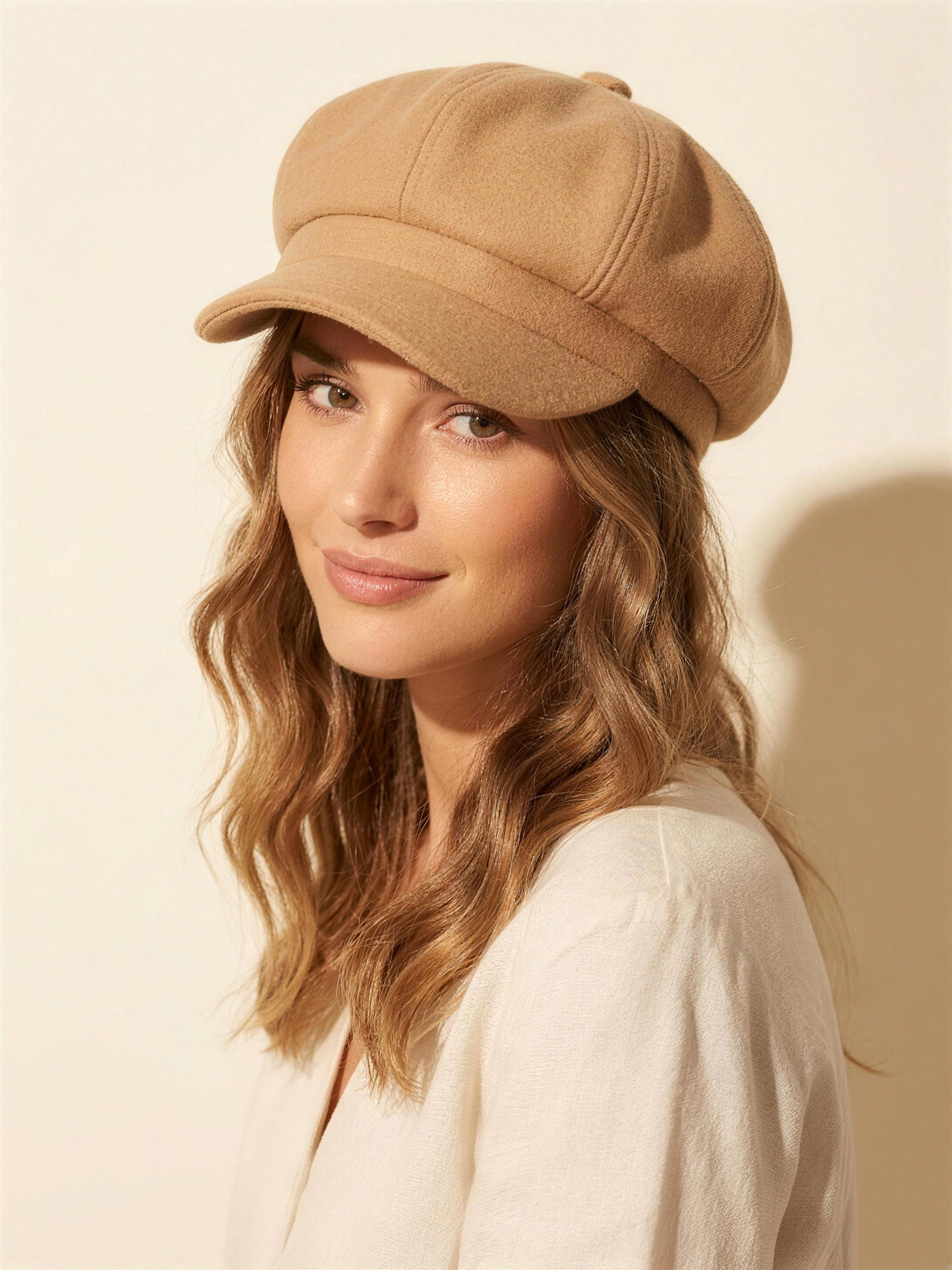 Camel wool baker-boy cap on model, warm ivory studio