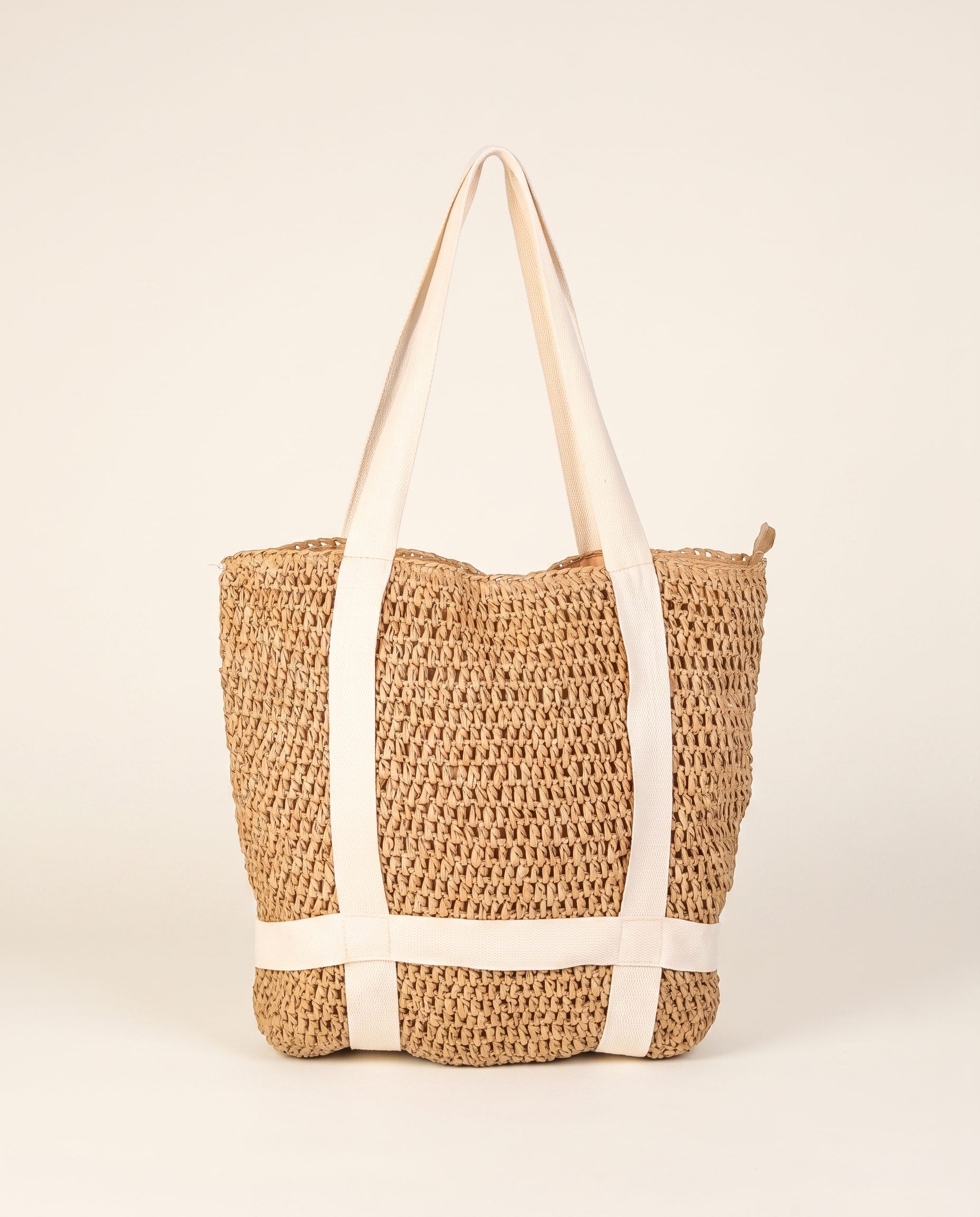Braided Straw Beach Tote on a warm ivory studio background