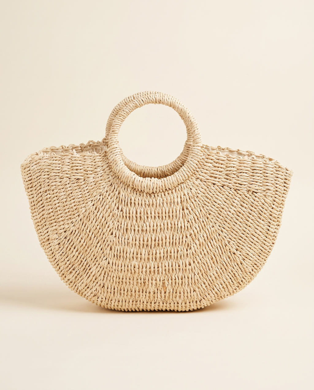 Half-Moon Straw Tote on a warm ivory studio background