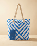 Blue cross-stripe insulated wine tote on a warm ivory background