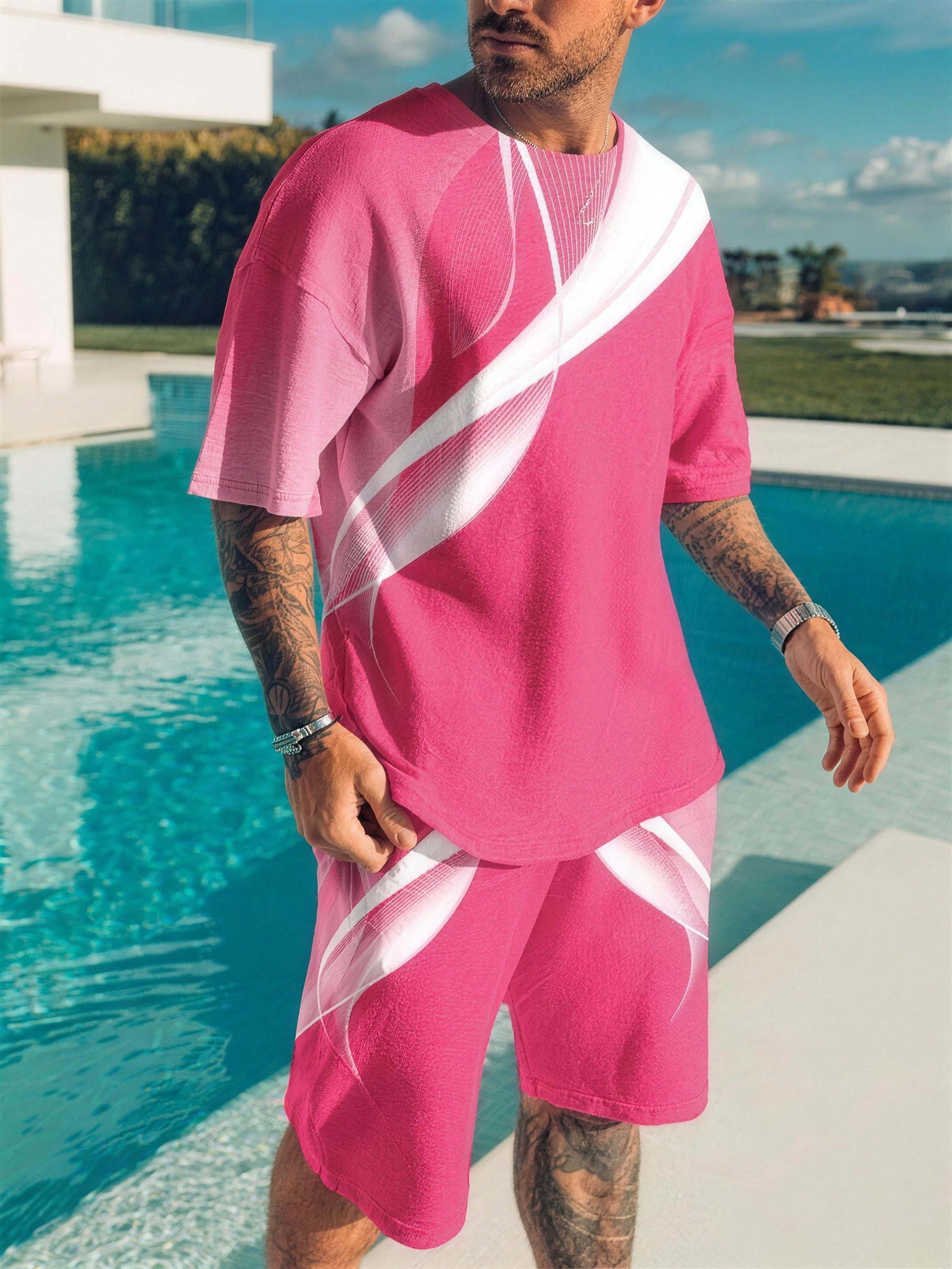 Men's pink contrast-print top and shorts set on model by pool