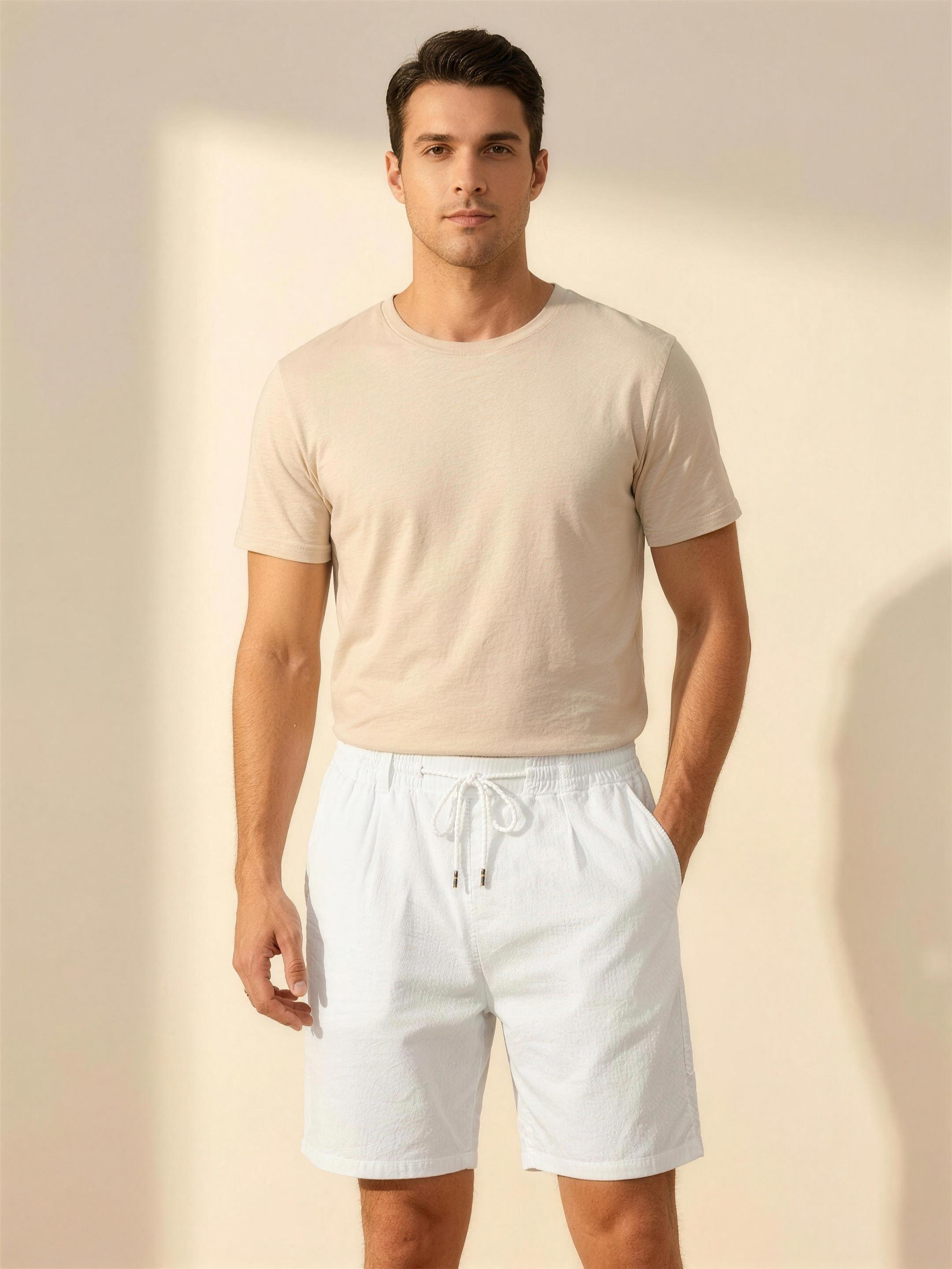 Men's white lightweight drawstring shorts on model, warm ivory studio