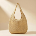 Woven straw beach tote bag in natural straw, warm ivory studio background